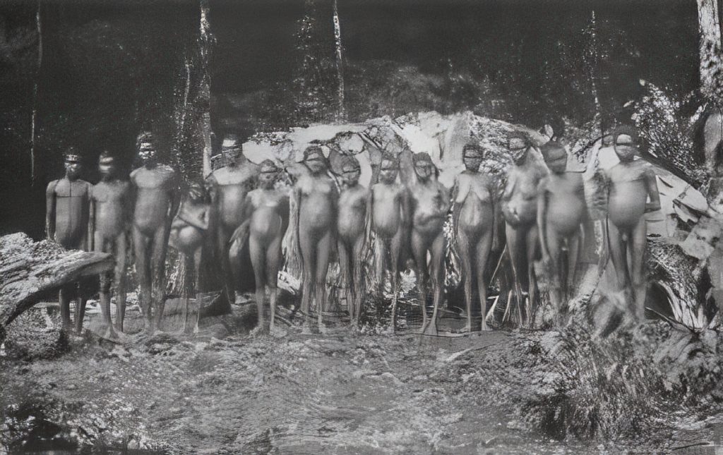 A group of rainforest people outside one of their palm leaf huts. Atherton-Herberton, north Queensland.