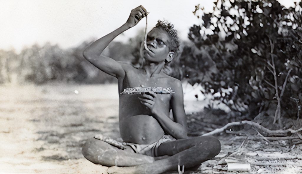 A boy eating a mangrove worm (a type of mollusc).